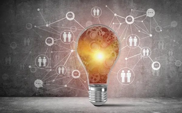 A lightbulb surrounded by bubbles of two human figures